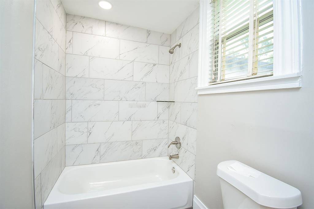Full-size bathroom on the first floor with a beautifully upgraded tub surround.