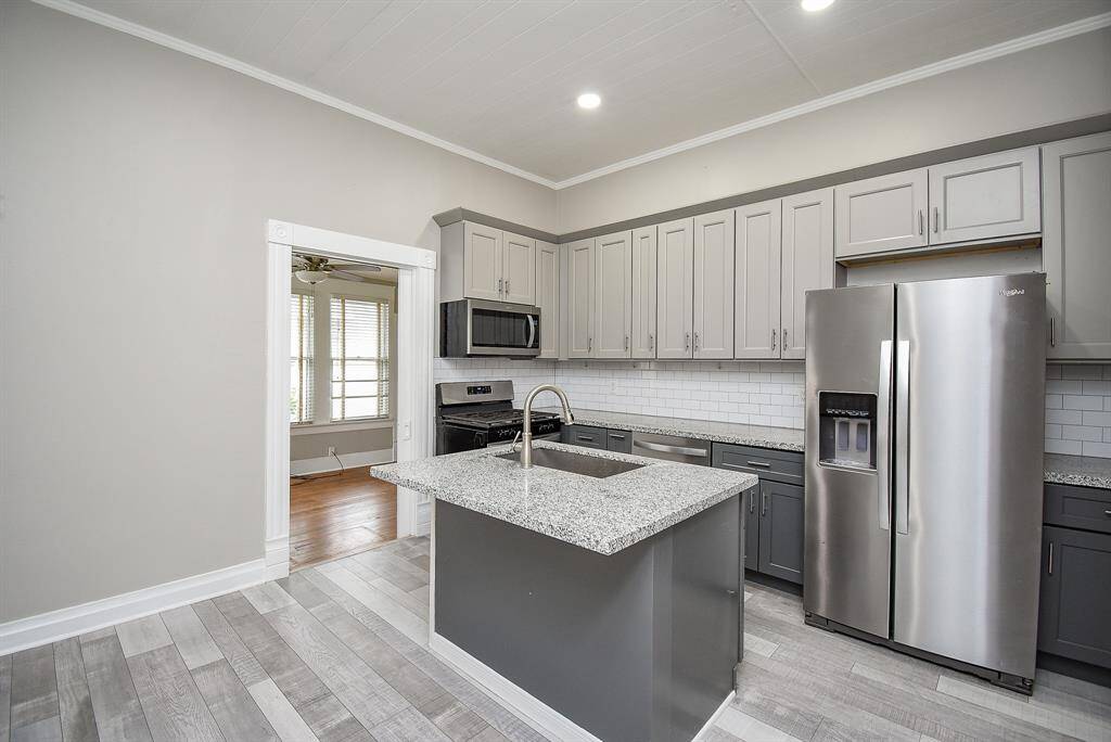 Kitchen with new two tone cabinets and stainless steel appliances.