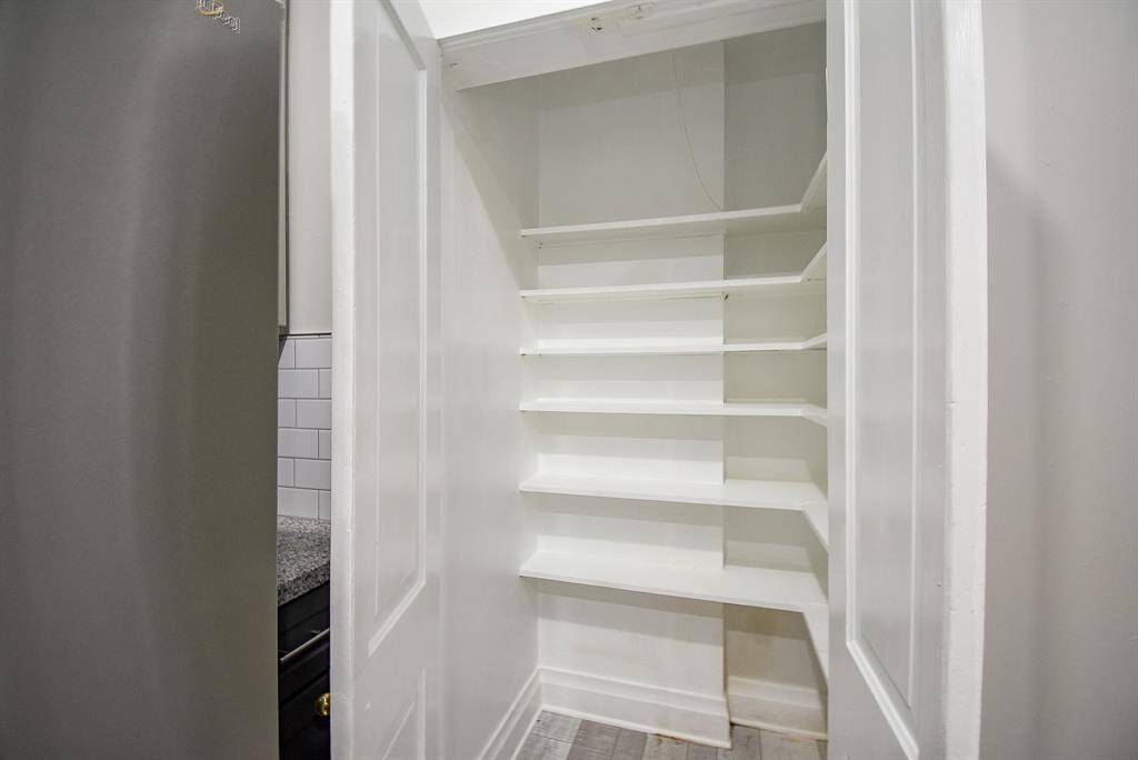 Compact pantry with multiple white shelves, providing ample storage space for kitchen essentials.