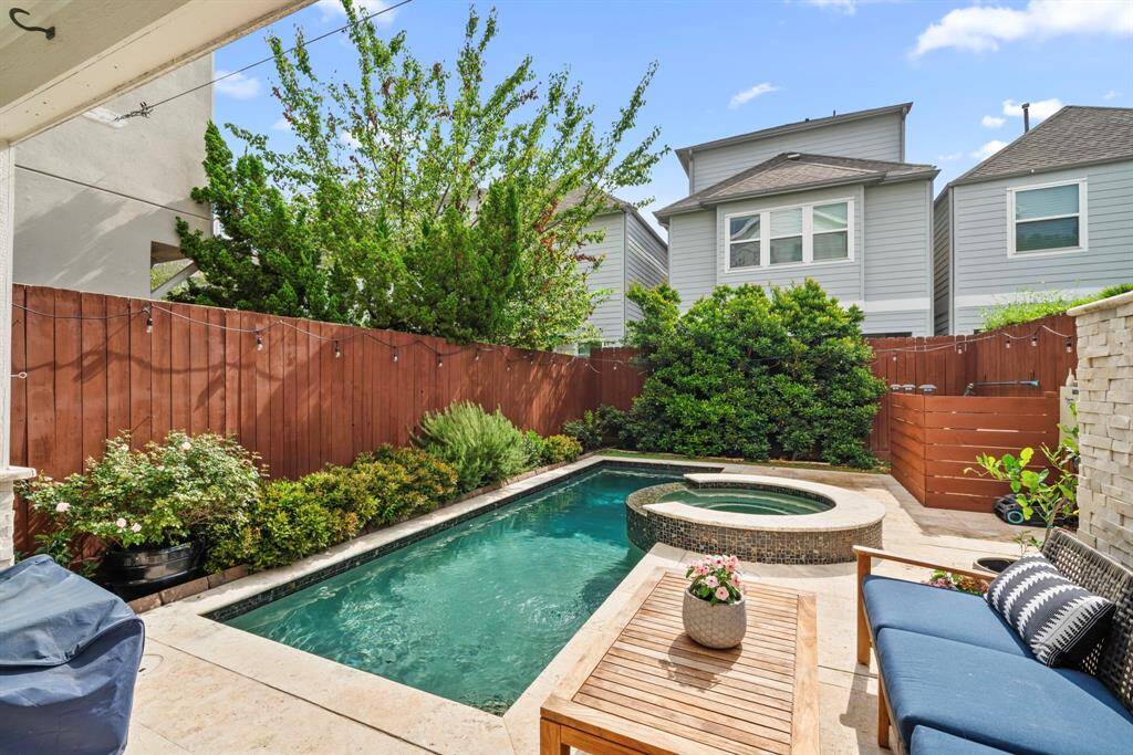 Covered patio with nice lush greenery. Pool features a separate spa feature.