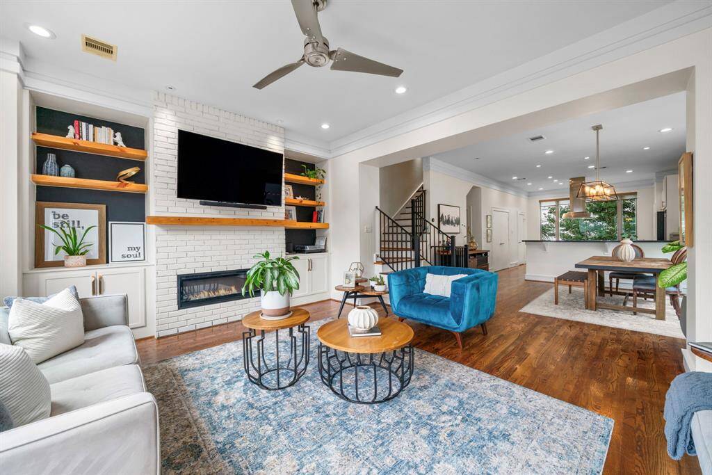 Many custom details like a custom entertainment center with a brick accent wall and electric fireplace. Living room opens up to rest of 2nd floor and has access to balcony.