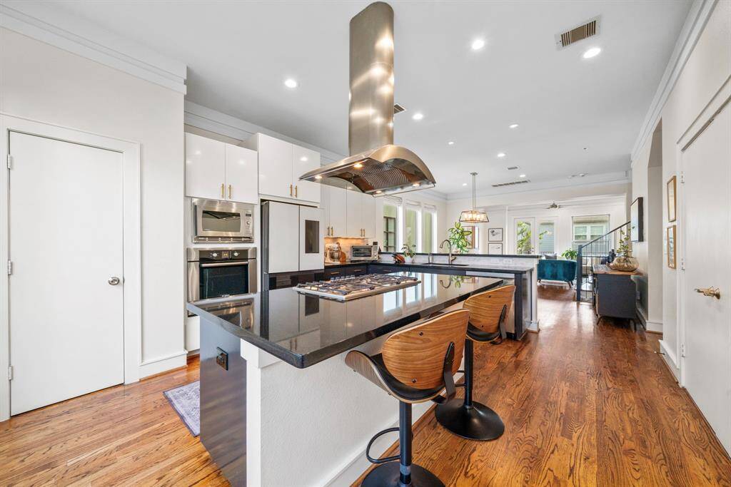 Island with gas grill and plenty of seating. Fridge stays.
