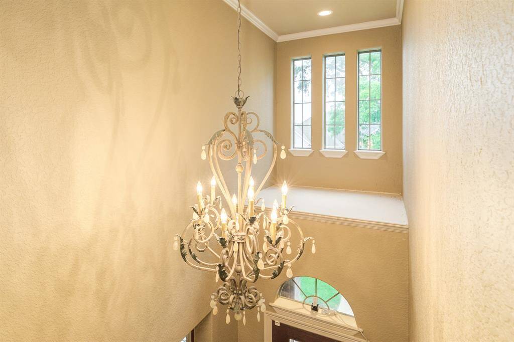 Elegant lighting throughout but this chandelier accents the entry way beautifully.