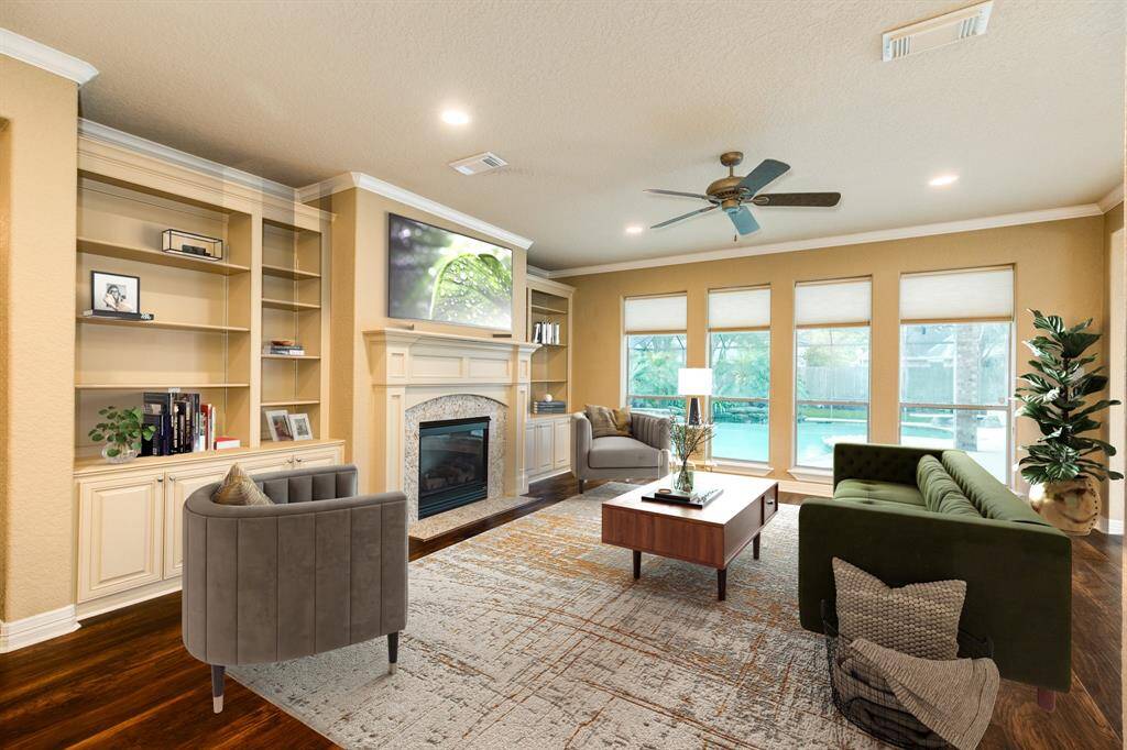 Virtually staged living room shows how fluid this space is. Whether your style is casual or sophisticated this spacious living room offers plenty of space.  Added features are custom built ins, a gas log fireplace, and tons of windows showcasing the resort style pool out back.