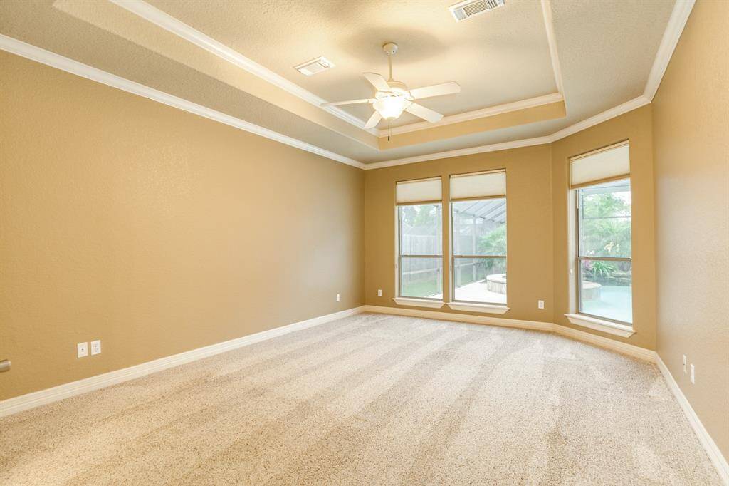 Generously sized primary with trayed ceilings and double crown molding for added appeal.