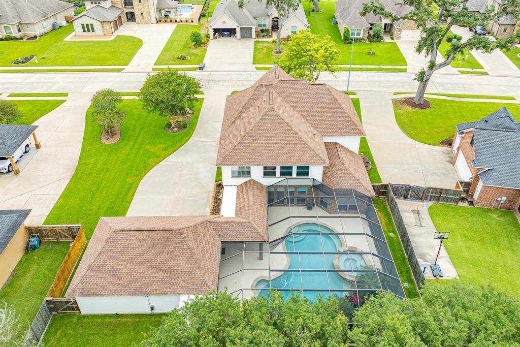 Ariel views of the back of home. Showcasing an impeccable roof and large screened area for added convenience.