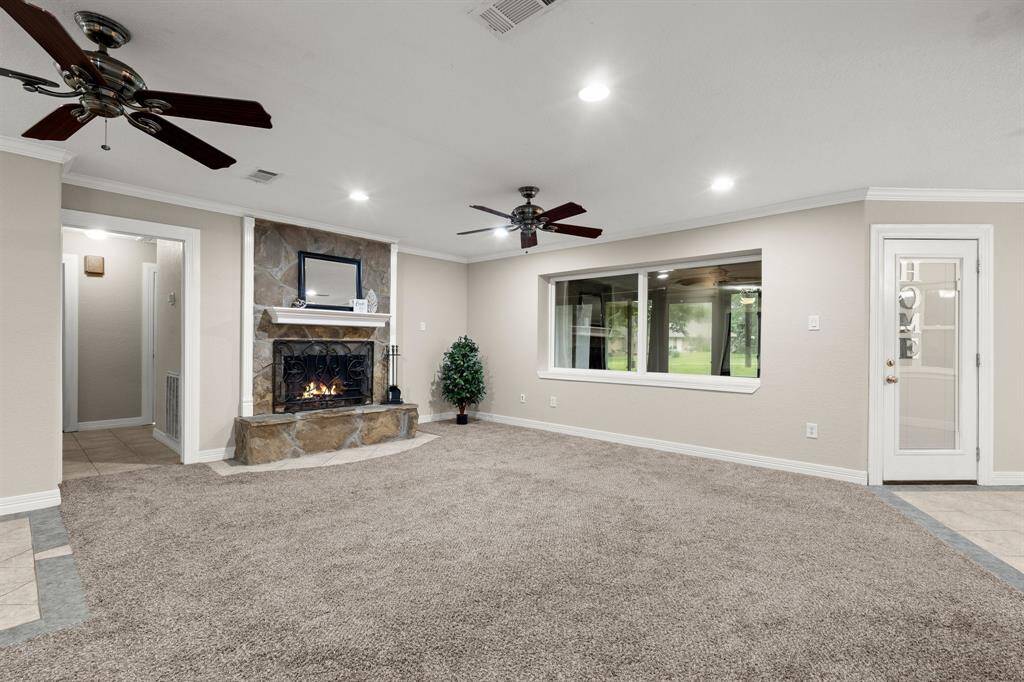 Living room with fireplace and large picture window looking out to the backyard.