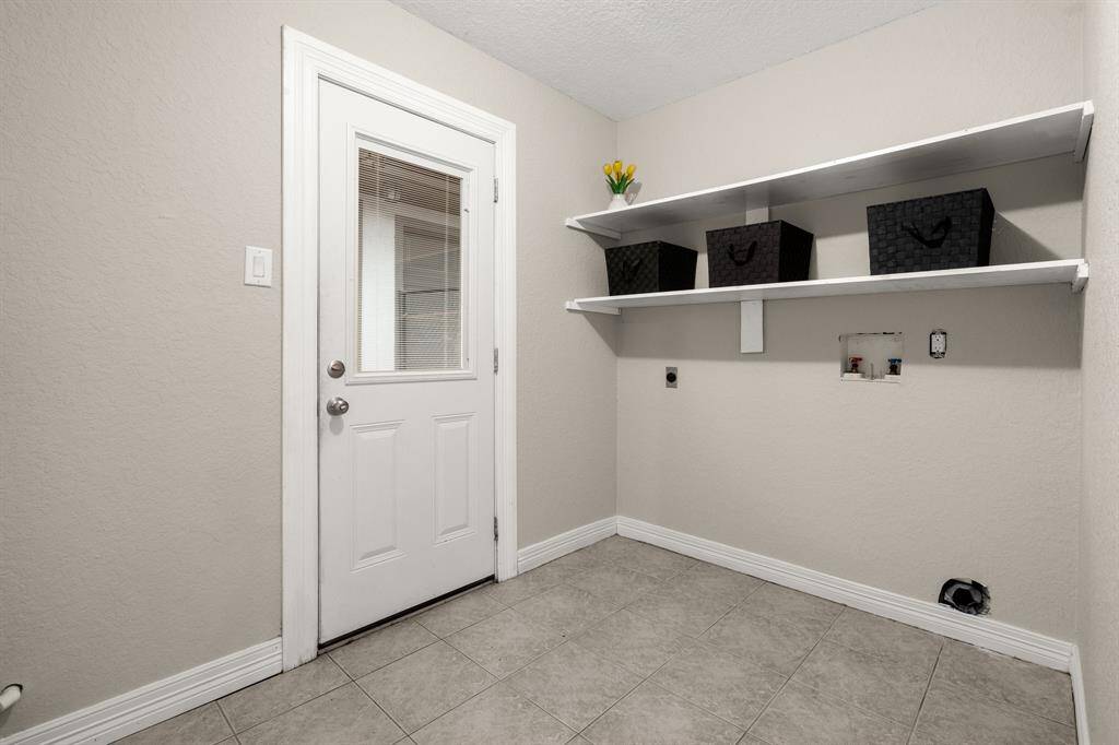 Laundry room with exterior door that has in-door blinds to provide privacy.
