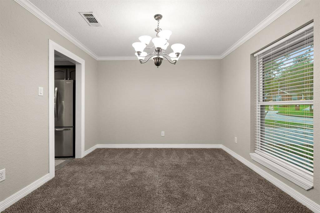 Formal dining room with chandelier and entry to the kitchen.