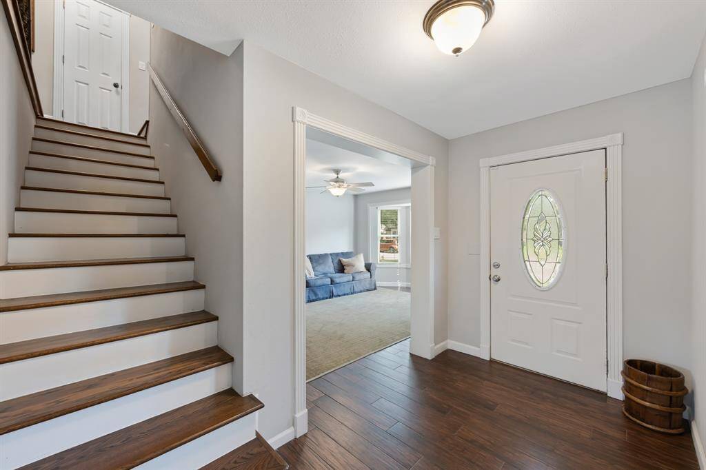As you step inside, you're greeted by stunning tile wood floors and crisp white walls. Bright natural light fills the space, creating an inviting and airy ambiance.