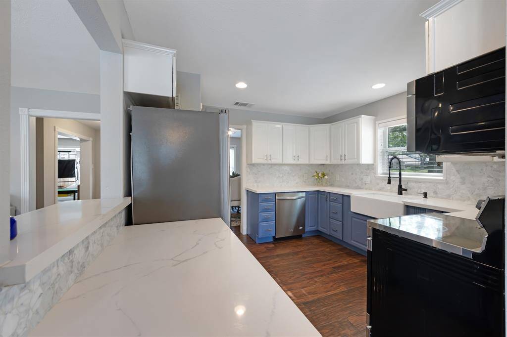 The kitchen features new quartz countertops and freshly painted white cabinets.