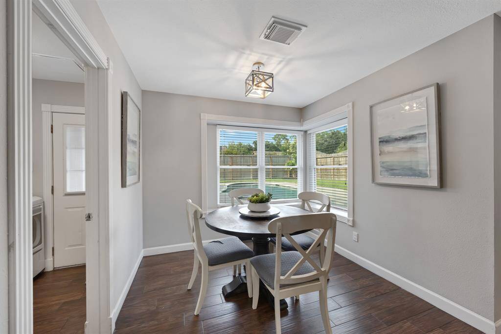 Charming breakfast nook features a cozy light fixture and inviting window ledges. You will serene views of the pool and backyard from this sunlit corner.