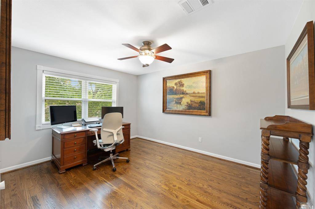 Versatile studio home office with stylish wood tile flooring and a sleek ceiling fan.