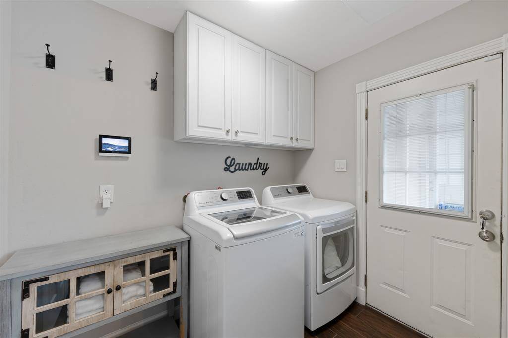 Laundry room is also adorned by the beautiful wood tile flooring from the rest of the house while featuring elegant white cabinetry for everyday tasks!