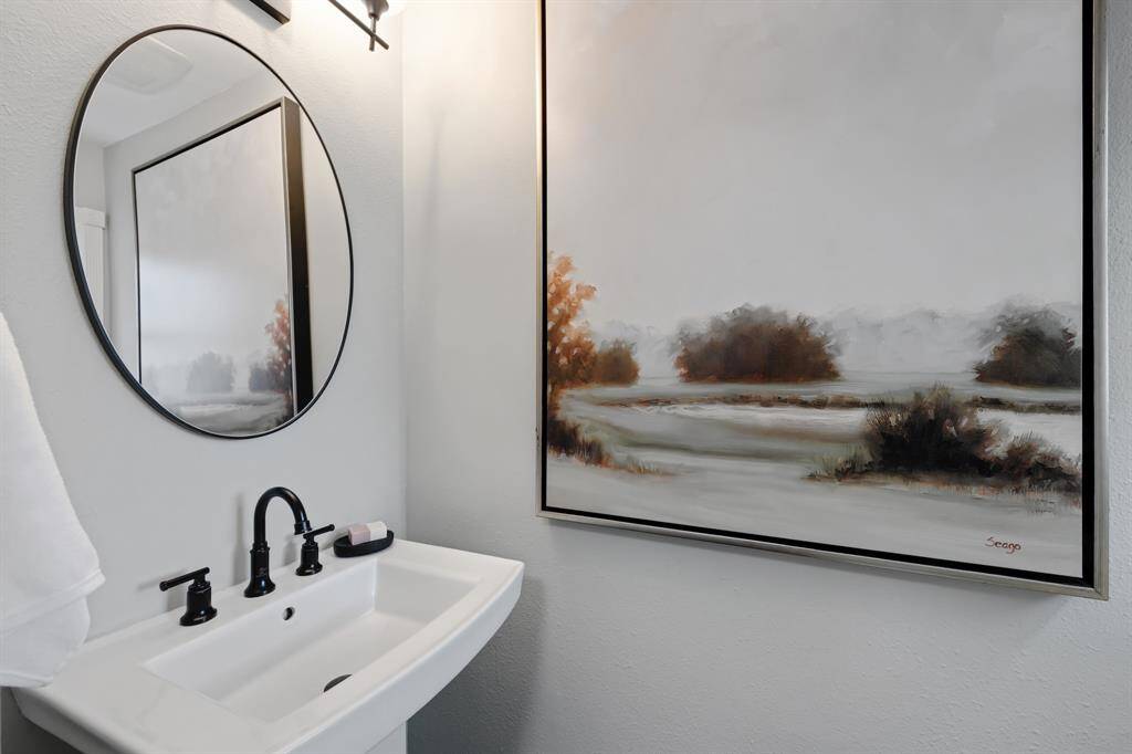 Beautifully updated bathroom featuring a striking new black-framed mirror and modern lighting that perfectly complements the clean, contemporary design.