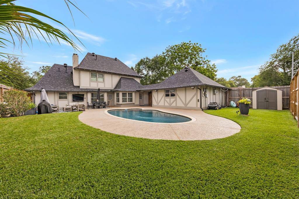 Resort-style living in this beautiful backyard featuring a sparkling pool, spacious patio, and lush green lawn. This serene outdoor space includes a covered lounge area and dining space. Relaxation, luxury and comfort in one space.