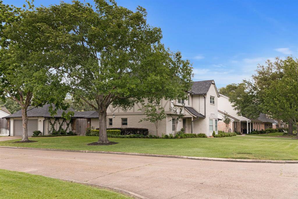 The home rests on a spacious corner lot with mature trees and manicured landscaping. Located in a quiet, tree-lined neighborhood.