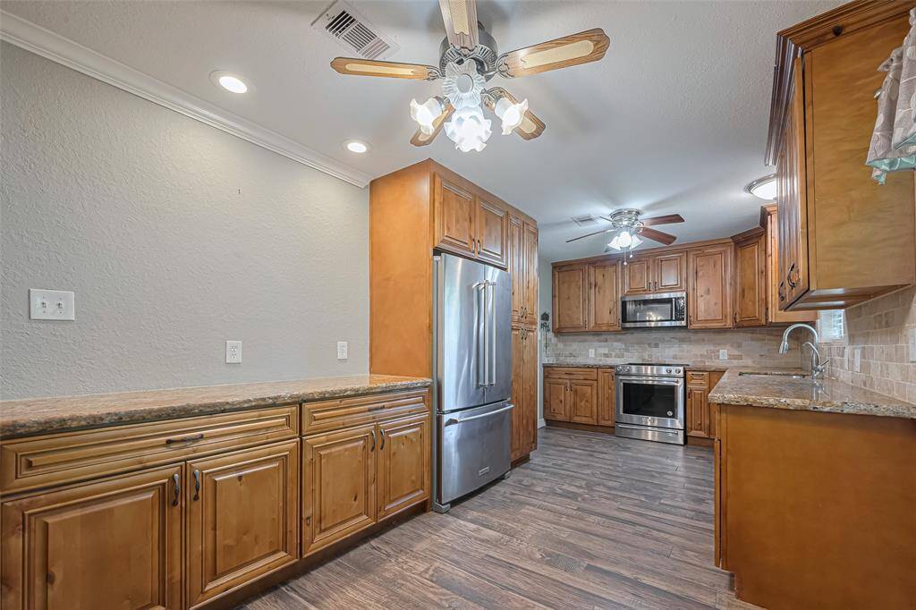 This updated kitchen features custom soft close wood cabinetry (loads of storage), stainless steel appliances, and granite countertops. It has recessed lighting, ceiling fans, and a spacious layout with a warm, inviting atmosphere.  RECENT REFRIGERATOR, MICROWAVE, DISHWASHER AND STOVE !!