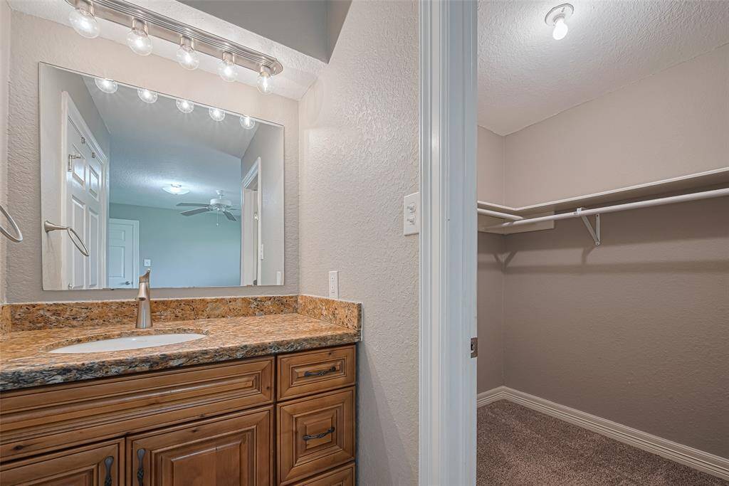 Spacious primary bedroom offers plenty of natural lighting from windows on two walls, a built-in wall storage cabinet, and an en-suite bathroom