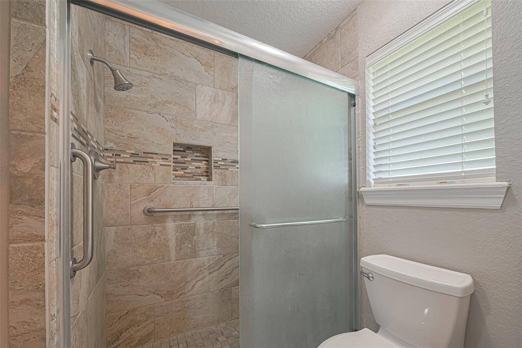 Primary bathroom features vanity with wood cabinets, granite countertop, a large mirror, and ample lighting. Adjacent is a large walk-in closet with shelving
