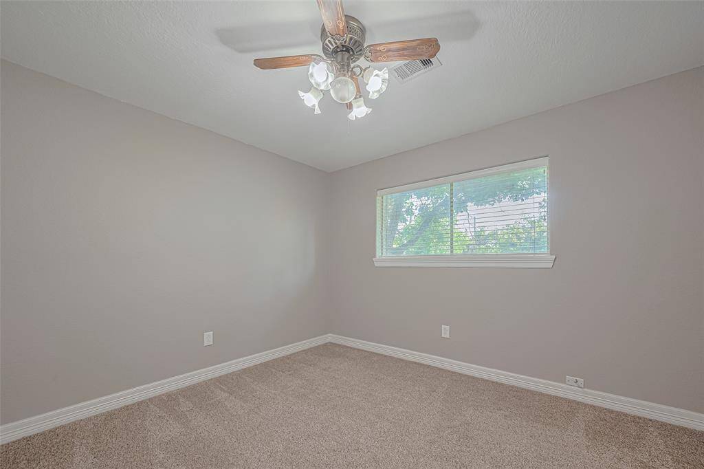 2nd bedroom offers natural lighting from a large window, fan, and ample-sized closet