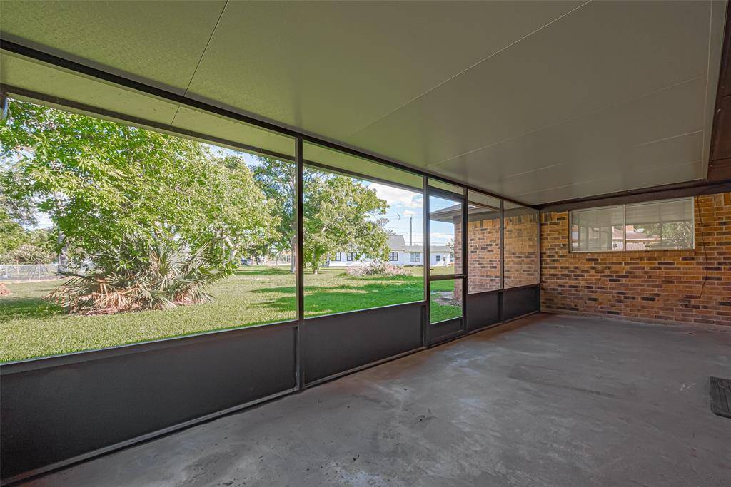 Leading out of living area, covered back patio offers plenty of space for outdoor activities and relaxation, with a view of the backyard through screened panels.  Enjoy the beauty of your backyard rain or shine!