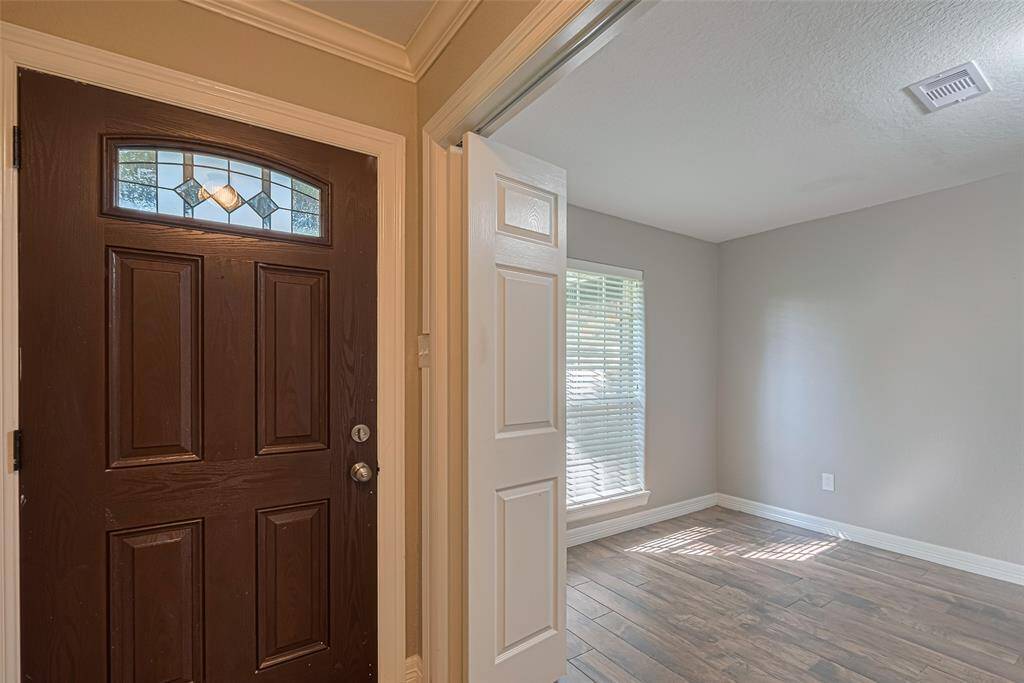 Front room off of entry offers lots of natural lighting, custom built-in wood cabinetry/desk, and double entry privacy doors that makes this perfect for office/study/hobby room