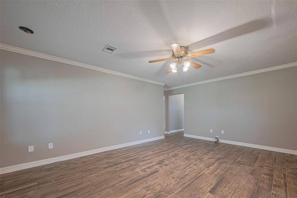 Open concept main living area offers tile flooring, crown molding, and loads of natural lighting from a large picture window overlooking the sun room and lush backyard