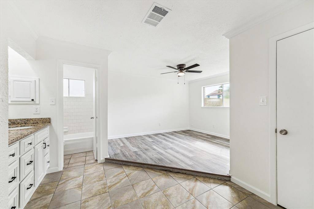ENJOY THE CLEAN, UPDATED LOOK OF NEW FLOORING AND CEILING FAN IN THIS BRIGHT PRIMARY RETREAT WITH AN OPEN VANITY AREA.