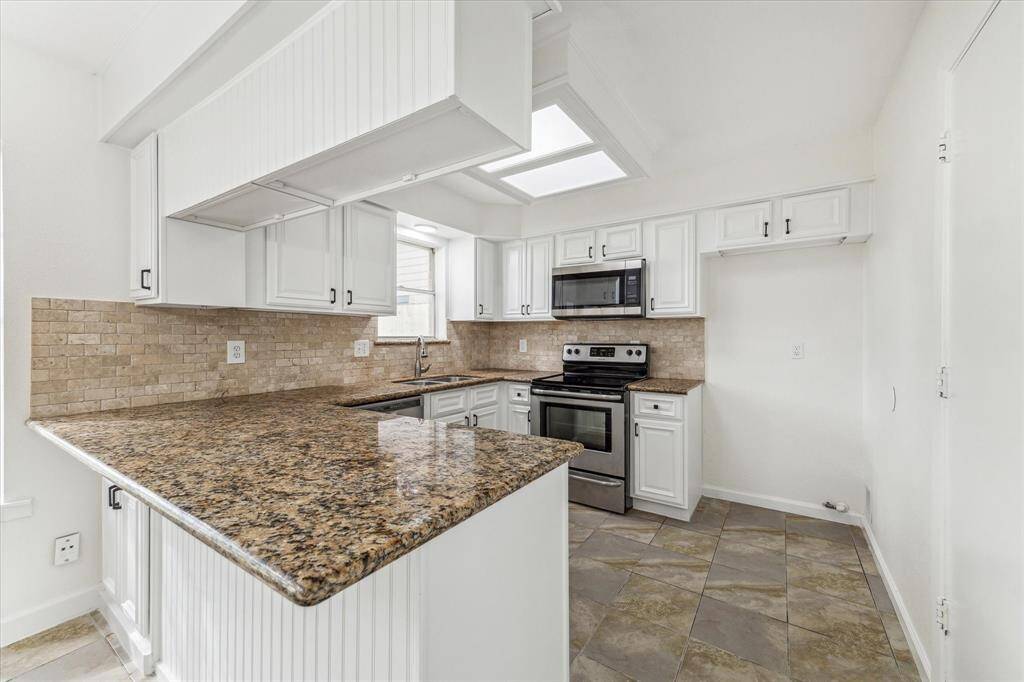 GENEROUS GRANITE COUNTERTOPS PROVIDE AMPLE PREP SPACE AND BREAKFAST BAR SEATING.