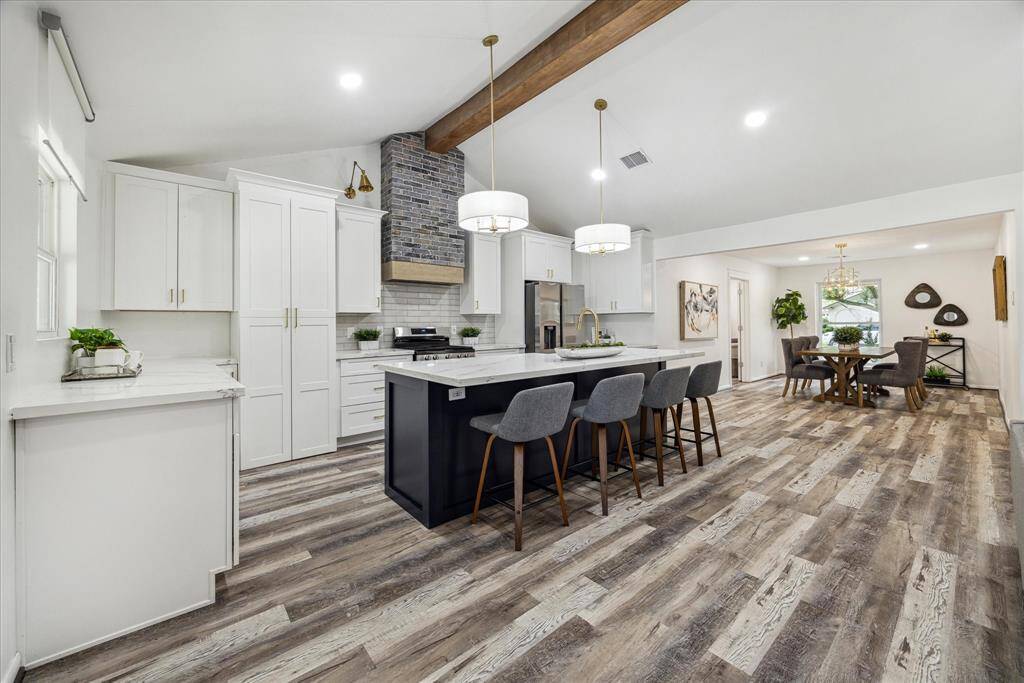Another perspective of the open-concept tfloor plan, featuring a stunning decorative wood beam