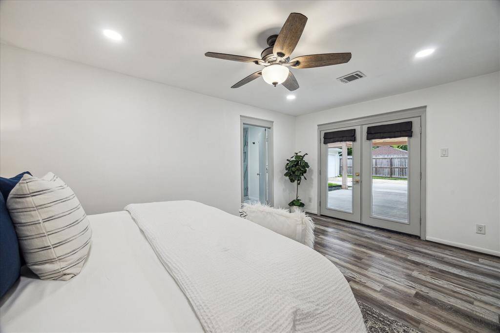The primary bedroom opens to the covered patio through elegant French doors.