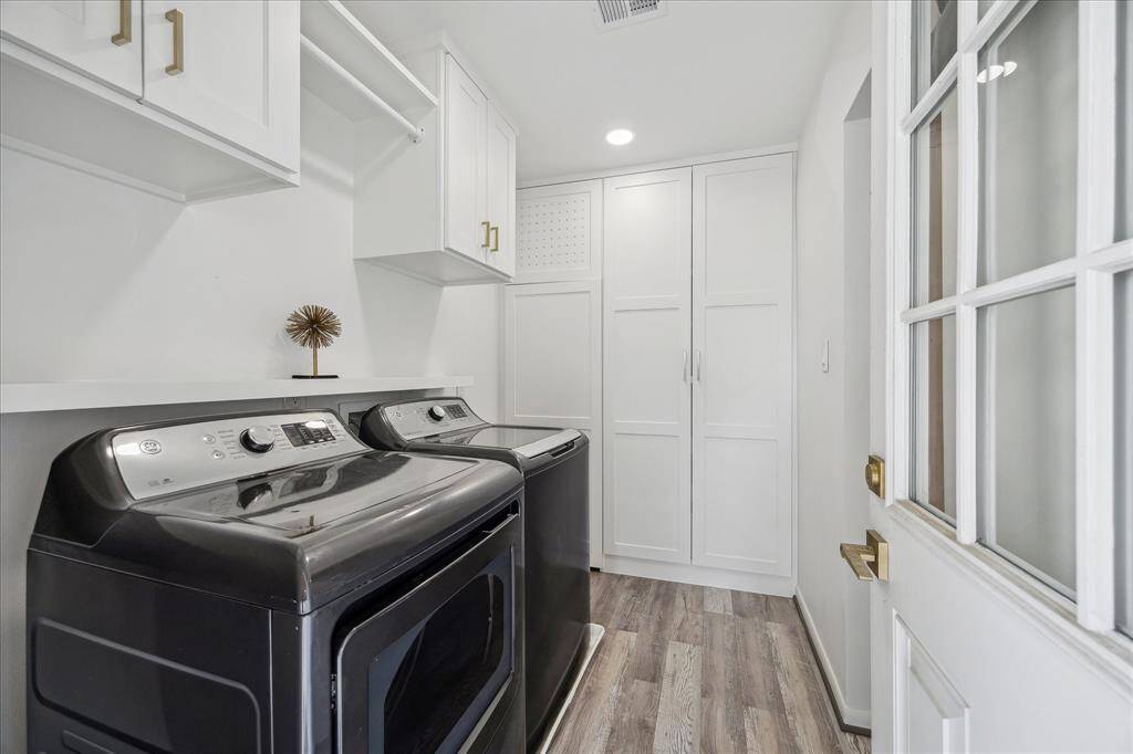 The utility room, located off the kitchen, features built-in storage and a convenient hanging rack for clothes