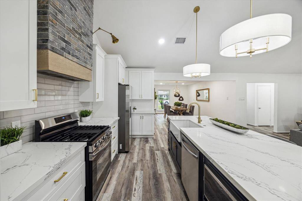 The kitchen boasts quartz countertops and a high-performance gas range. The cabinets and drawers are equipped with soft-close mechanisms.