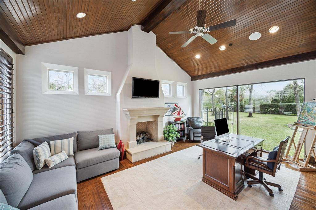 Stunning study/office space with custom fireplace, vaulted ceiling and floor to ceiling windows with verdant views.