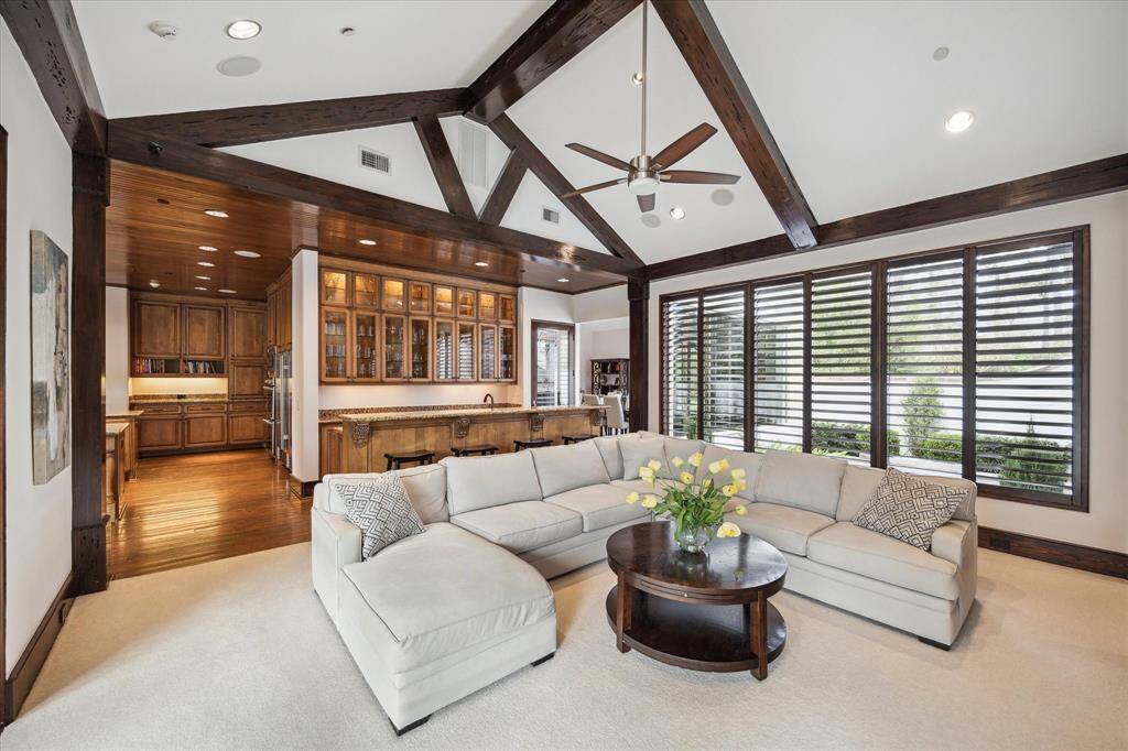 Another view of the formal living space shows the wet bar and a wall of windows on both sides.