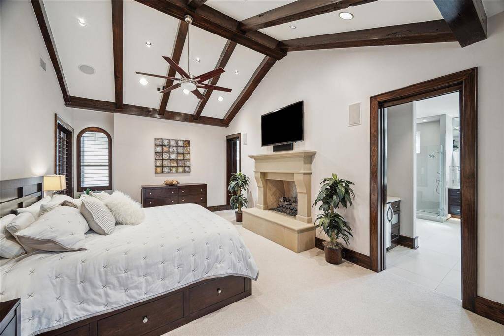 Primary suite with beamed vaulted ceiling, fireplace and pool access.