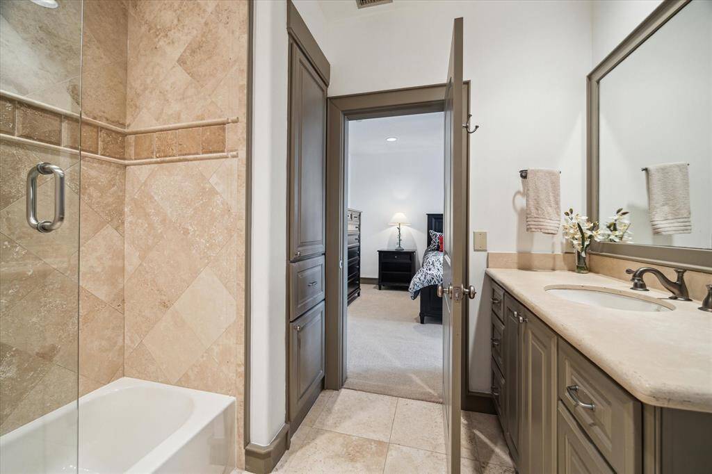 Bath to second bedroom with half glass wall at tub and great storage.