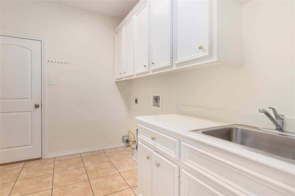 Large laundry room with storage and a sink.