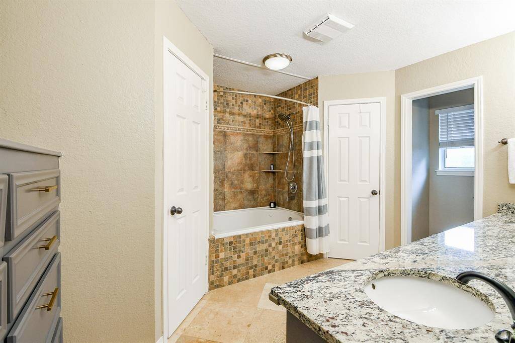 Primary bath with soaking tub, gorgeous tile and built in cabinet