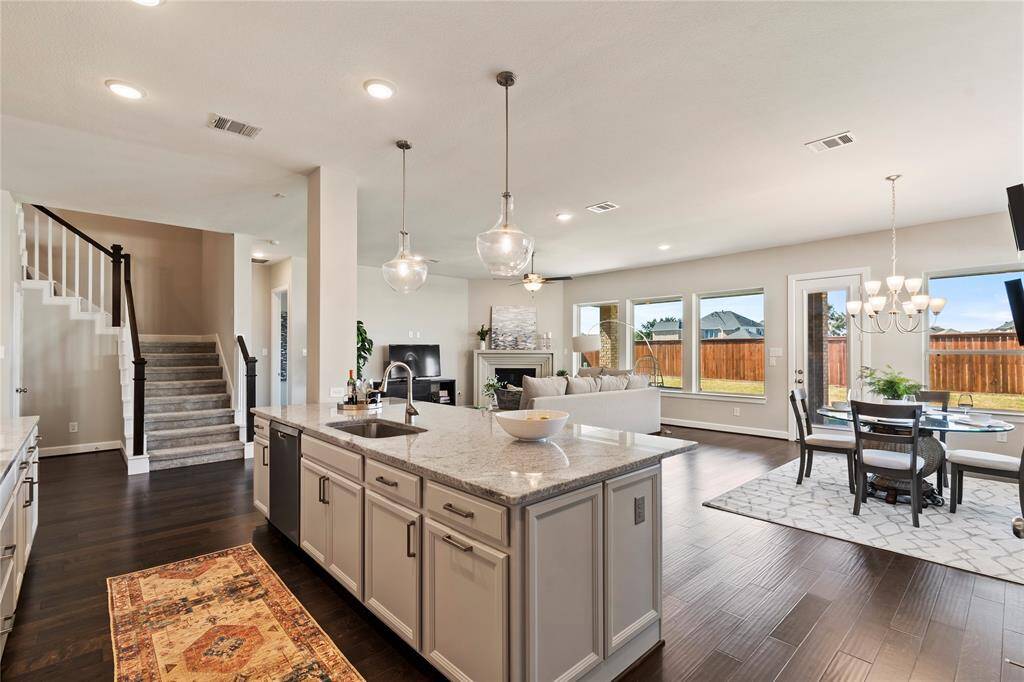 kitchen: Open-concept layout featuring large island kitchen, dining, and family room with back yard views
