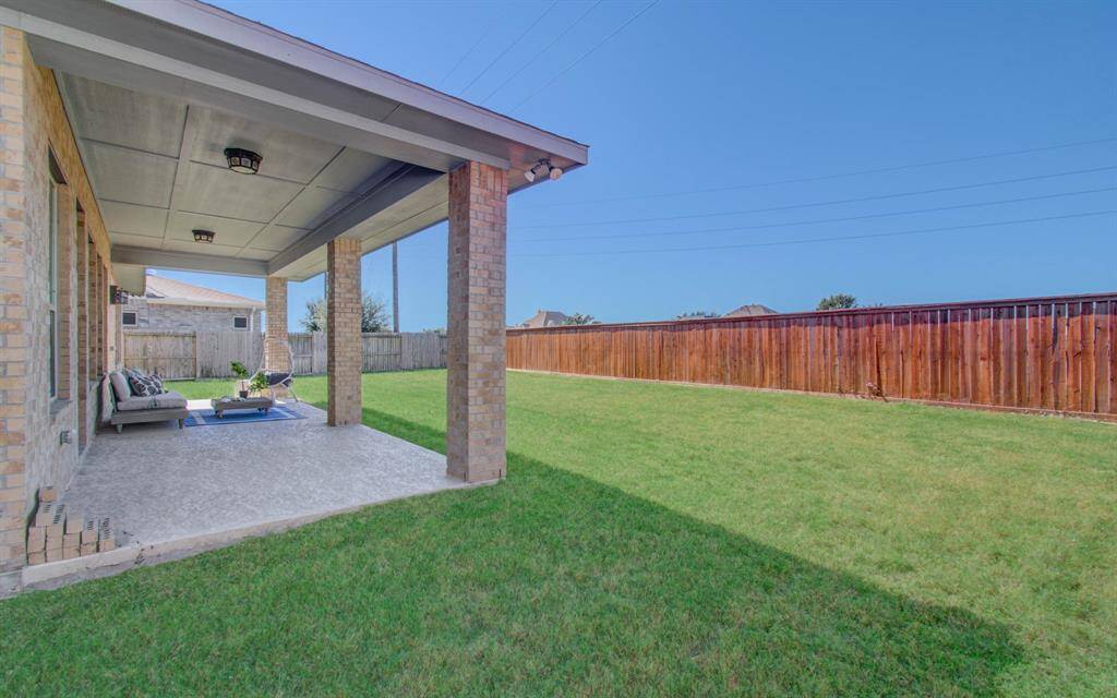 Extended covered patio overlooking a well-maintained lawn