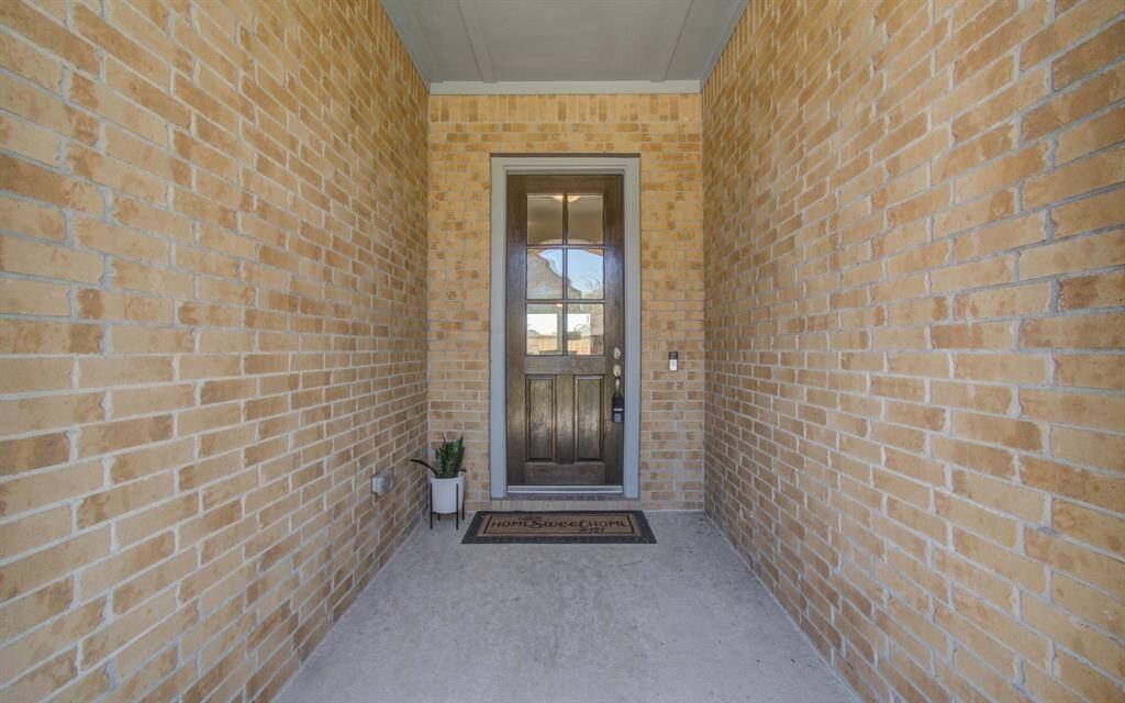 "Stately façade with brick and stone, manicured lawn, and an inviting entrance."