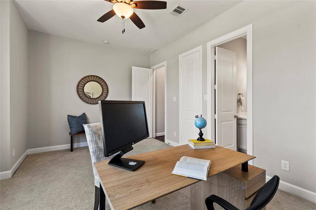 "Bright guest bedroom with large front windows, private full bath, and home office potential."