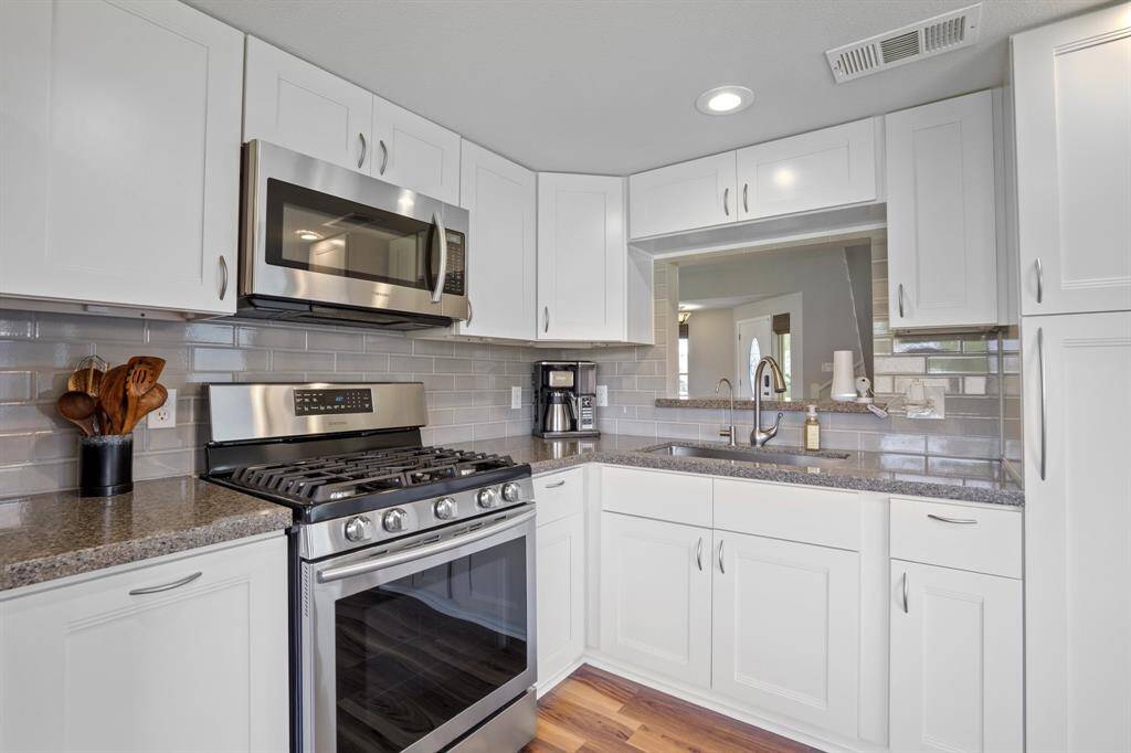 Off the other side of the family room is this quaint and gorgeous kitchen complete with gas stove and microwave.
