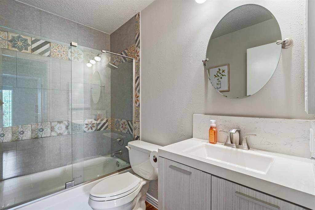 Nicely remodeled full bathroom that the secondary bedrooms share. Upgraded cabinets, sink, custom designed tilework in the shower/tub combo.