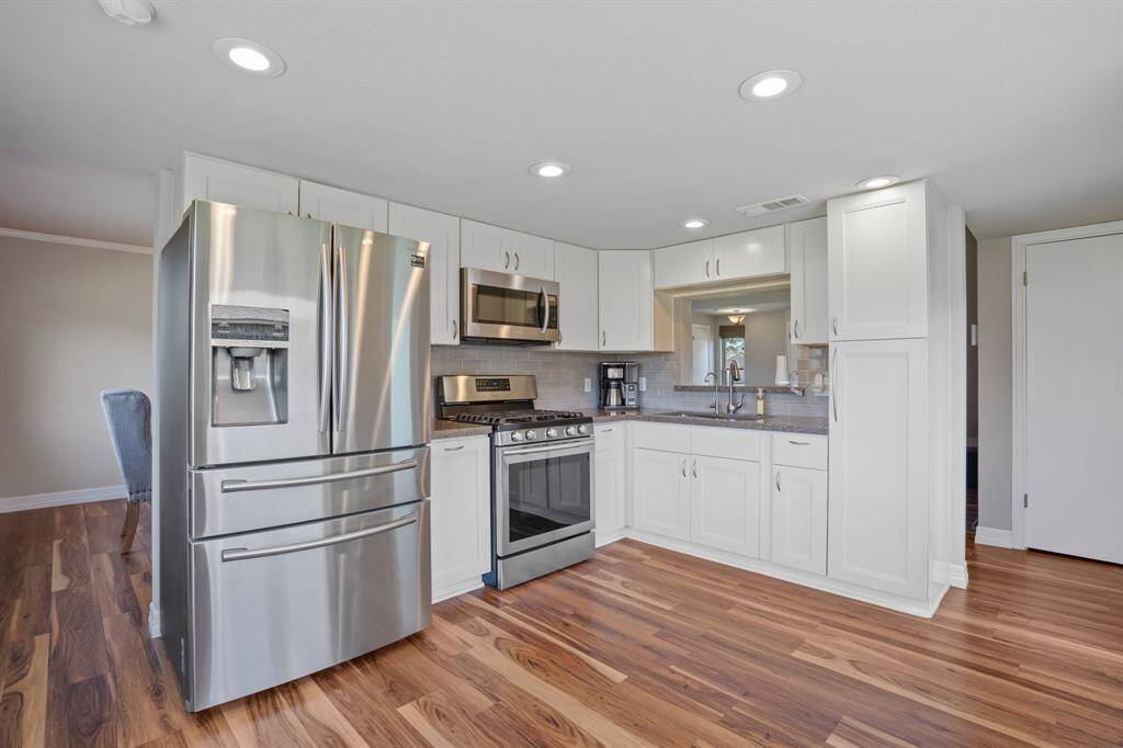 Renovated kitchen: granite countertops, cabinets, tile backsplash, appliances and flooring.