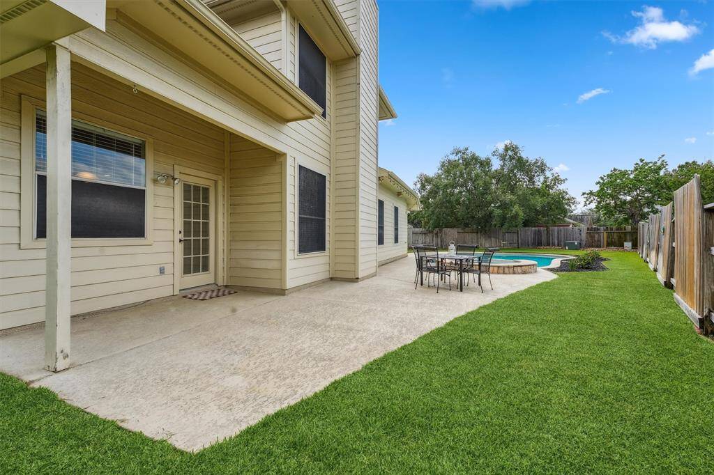 Large backyard with a pool/spa and plenty of green space.