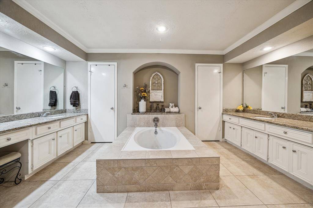 The spacious primary bedroom boasts a beautifully designed en suite bathroom featuring a relaxing soaking tub, separate walk-in shower, and dual vanities. Two generous walk-in closets offer ample storage and organization, making this suite a true retreat.