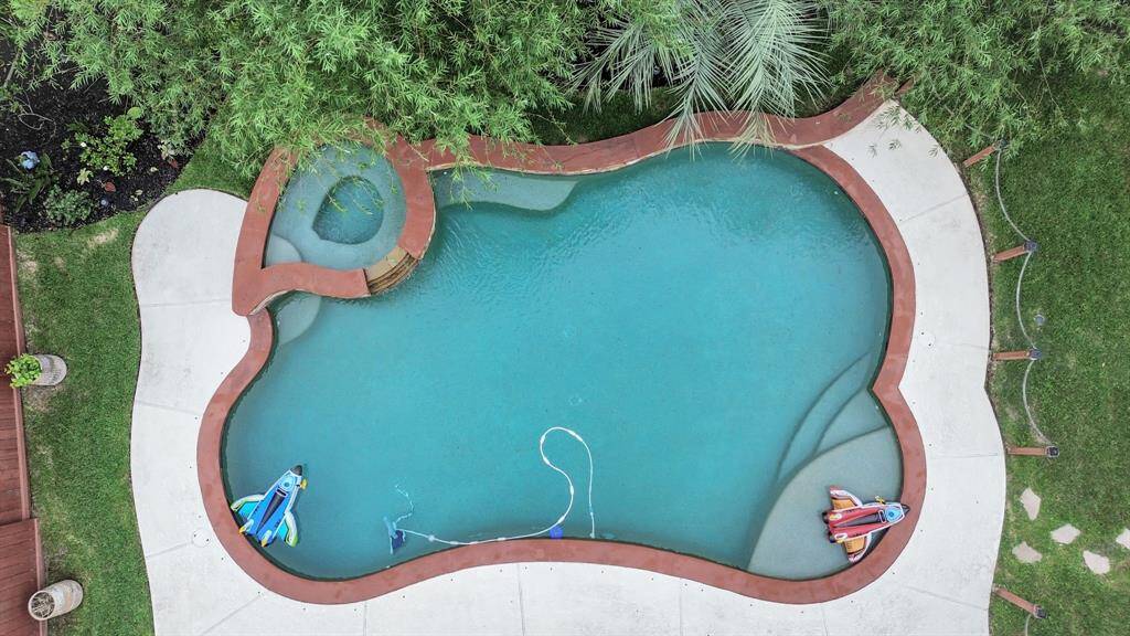Private backyard pool and spa surrounded by lush greenery. Perfect for relaxation and outdoor enjoyment.